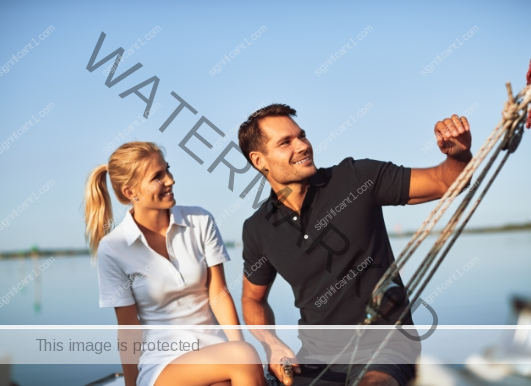 smiling-young-couple-sailing-their-yacht-on